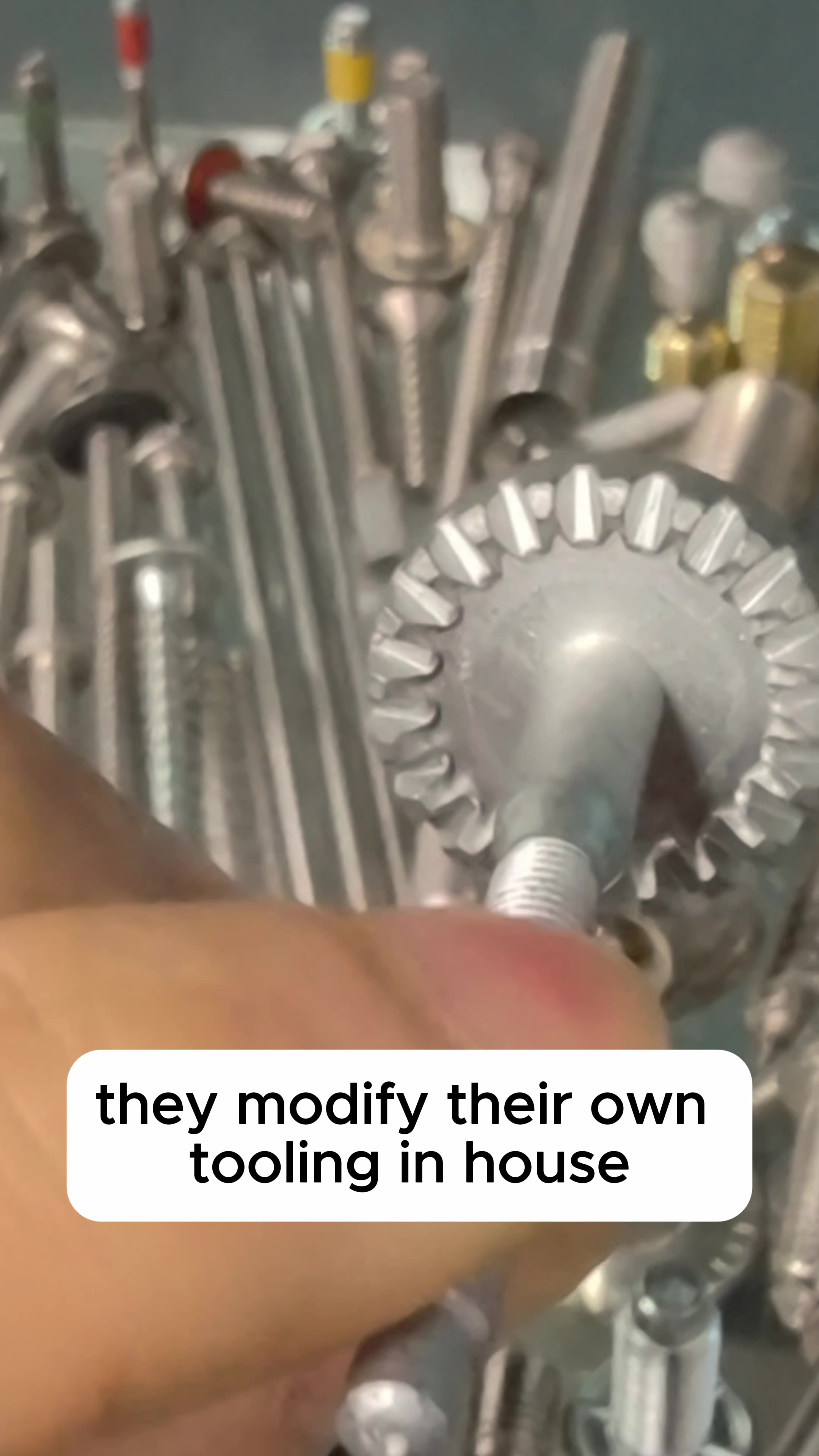 A cold-formed gear-toothed screw head among an array of complex fasteners in a Taiwan factory.